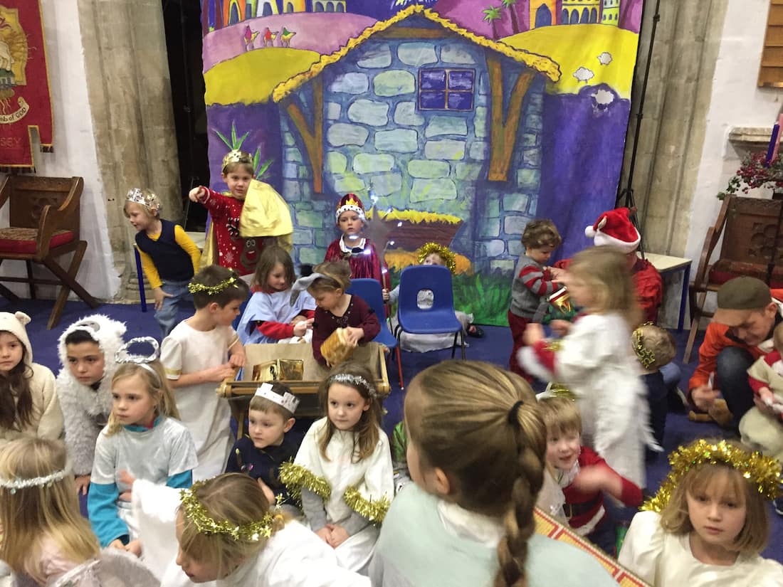 Nativity scene, painted backdrop with actors in stage.