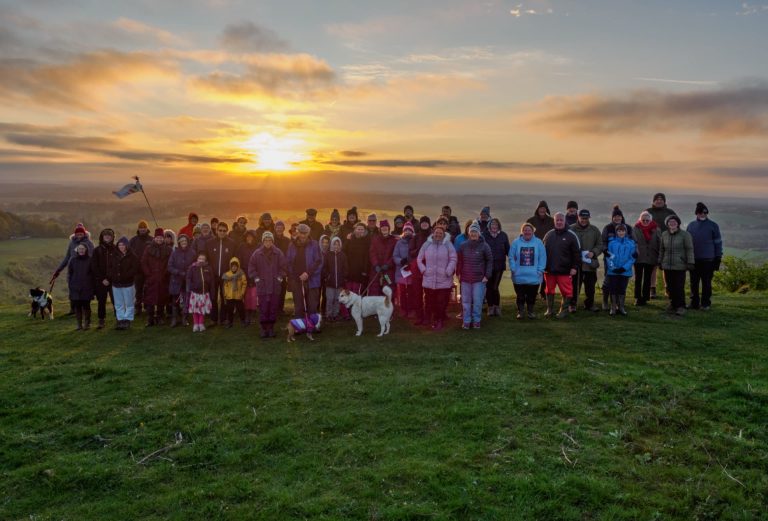 Group of people on a hill, with sunrise behind - celebrating Easter