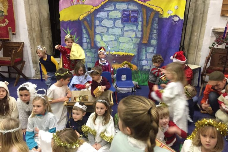 Nativity scene, painted backdrop with actors in stage.